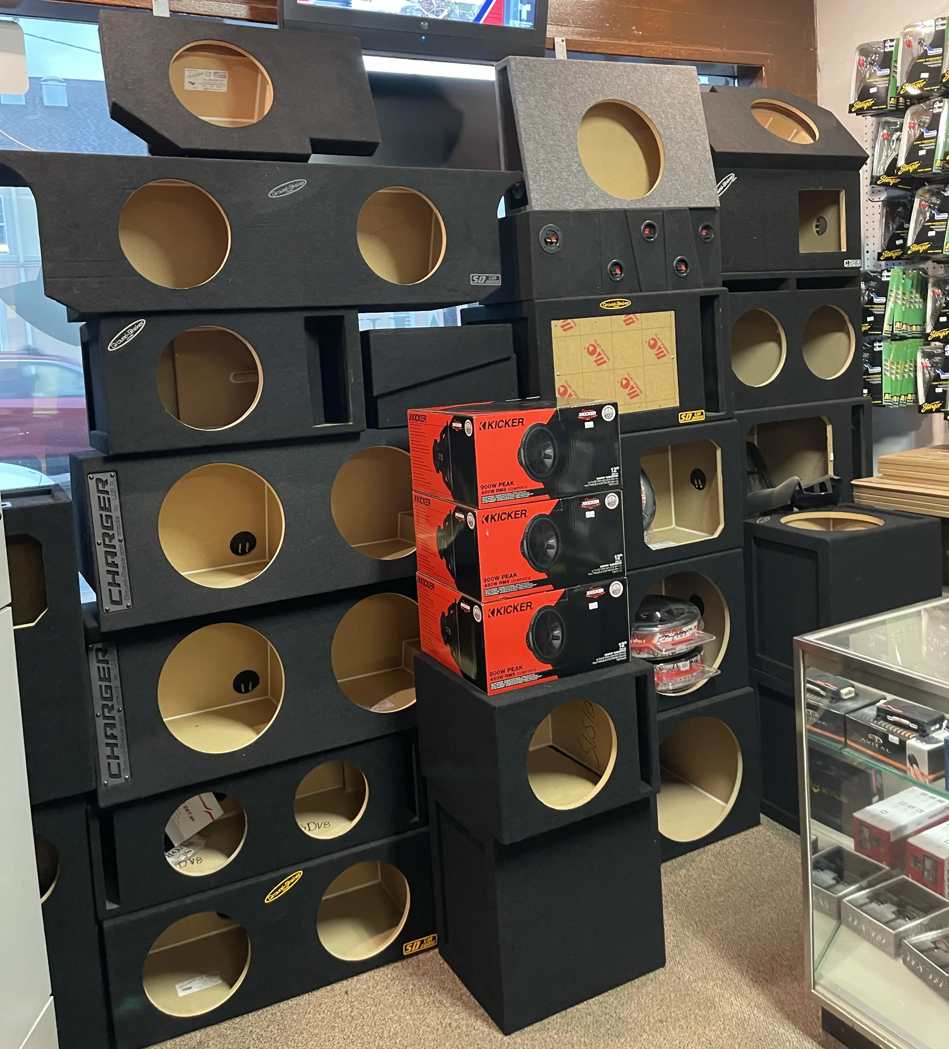 Subwoofer boxes stacked in front of store window.