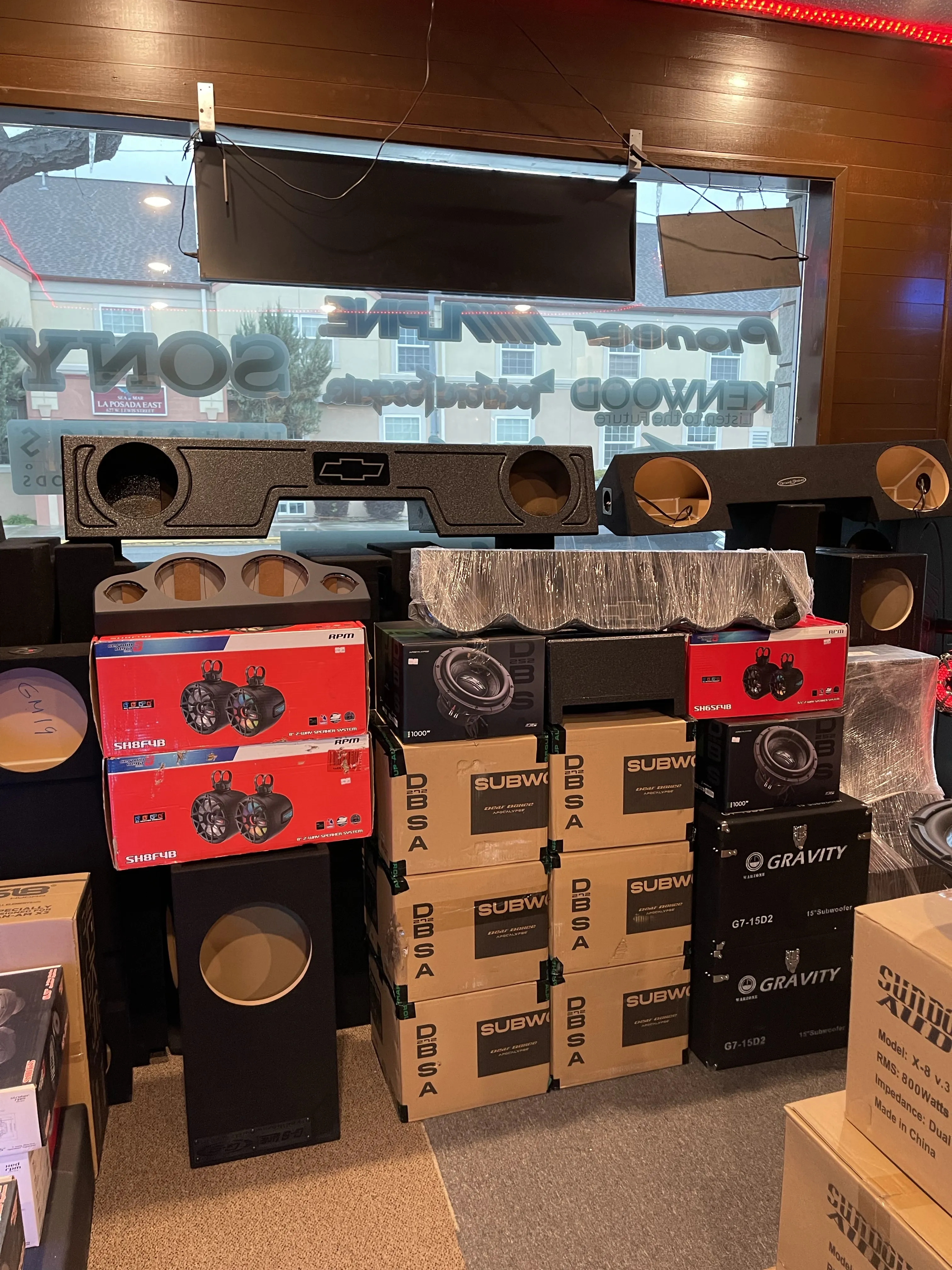 Assorted subwoofer-related products in front of store window.
